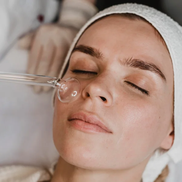 Une femme reçoit un traitement facial Hydrafacial à Montréal, utilisant un tube pour l'application des produits.