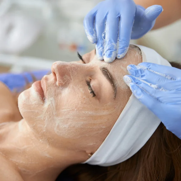 Une femme reçoit un soin du visage dans un salon de beauté à Montréal.