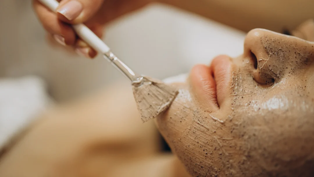 Une femme reçoit un soin du visage avec un pinceau à Montréal, mettant en avant un nettoyage de peau professionnel.